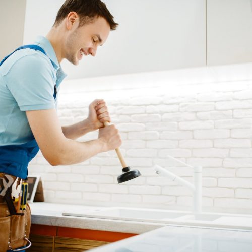 male-plumber-in-uniform-holds-plunger-clog.jpg