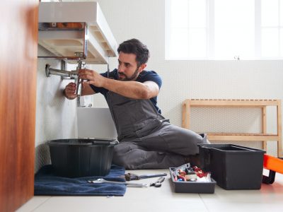 male-plumber-working-to-fix-leaking-sink-in-home-bathroom.jpg